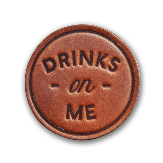 leather coaster reads Drinks on Me