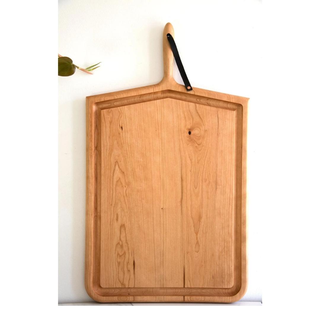 Oversized rectangular carving board in cherry wood with handle and leather strap