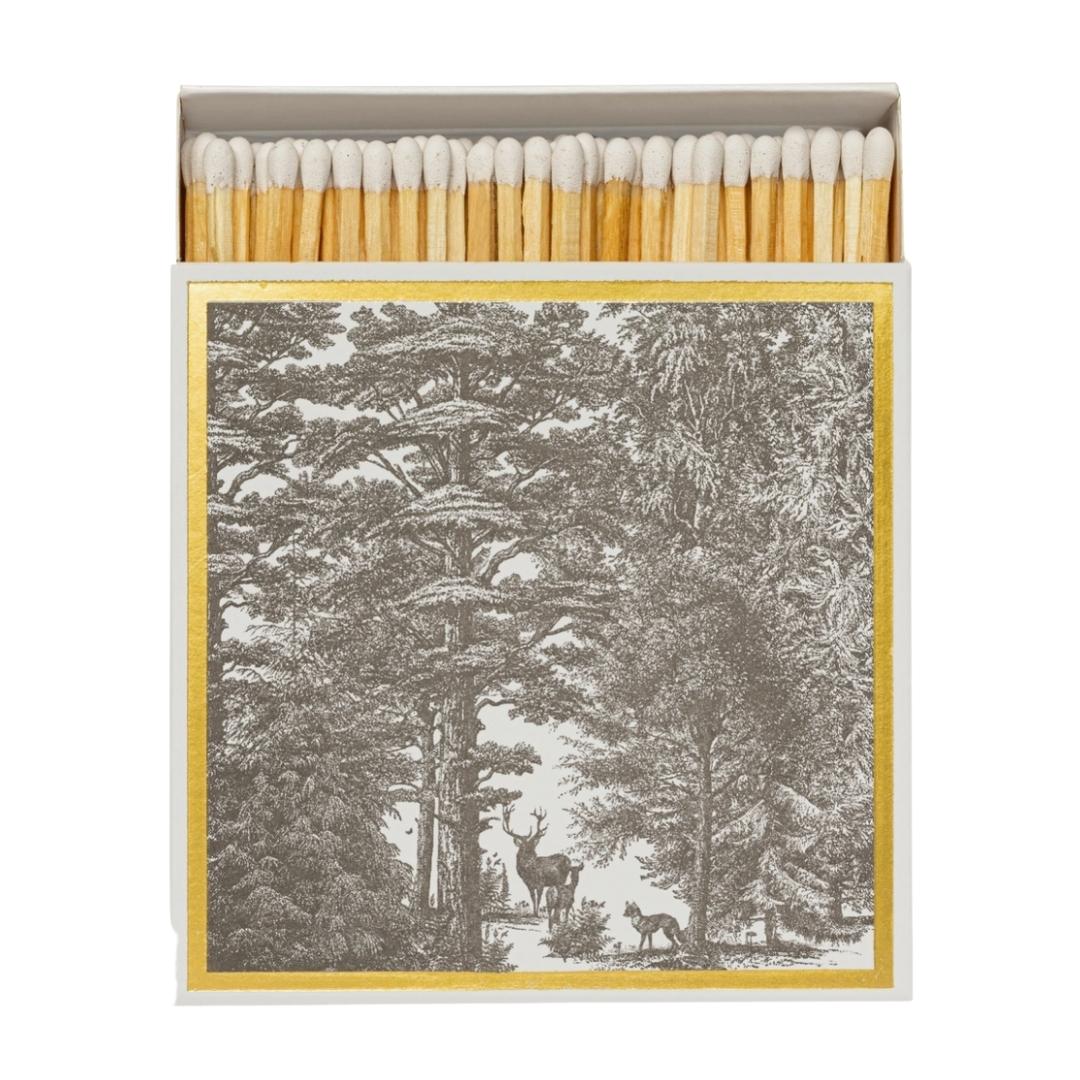 Square box of long wooden matches with black and white forest scene including dear and fox