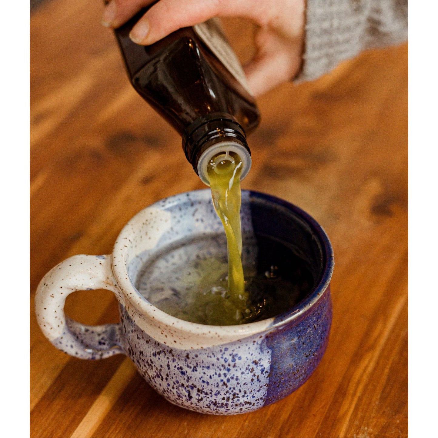 fire cider pouting into ceramic tea mug