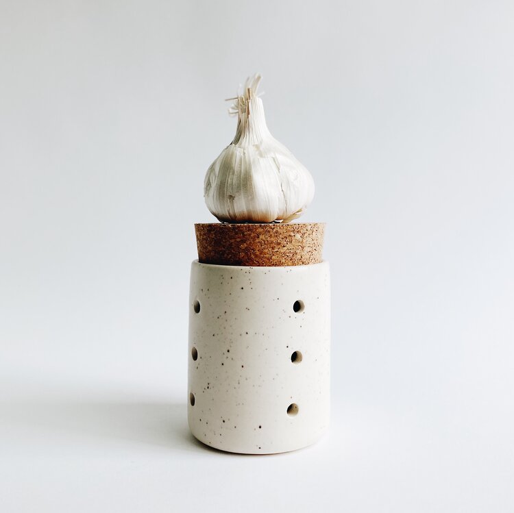 4 inch tall hand-thrown ceramic garlic jar in speckled white with holes for aeration and cork top