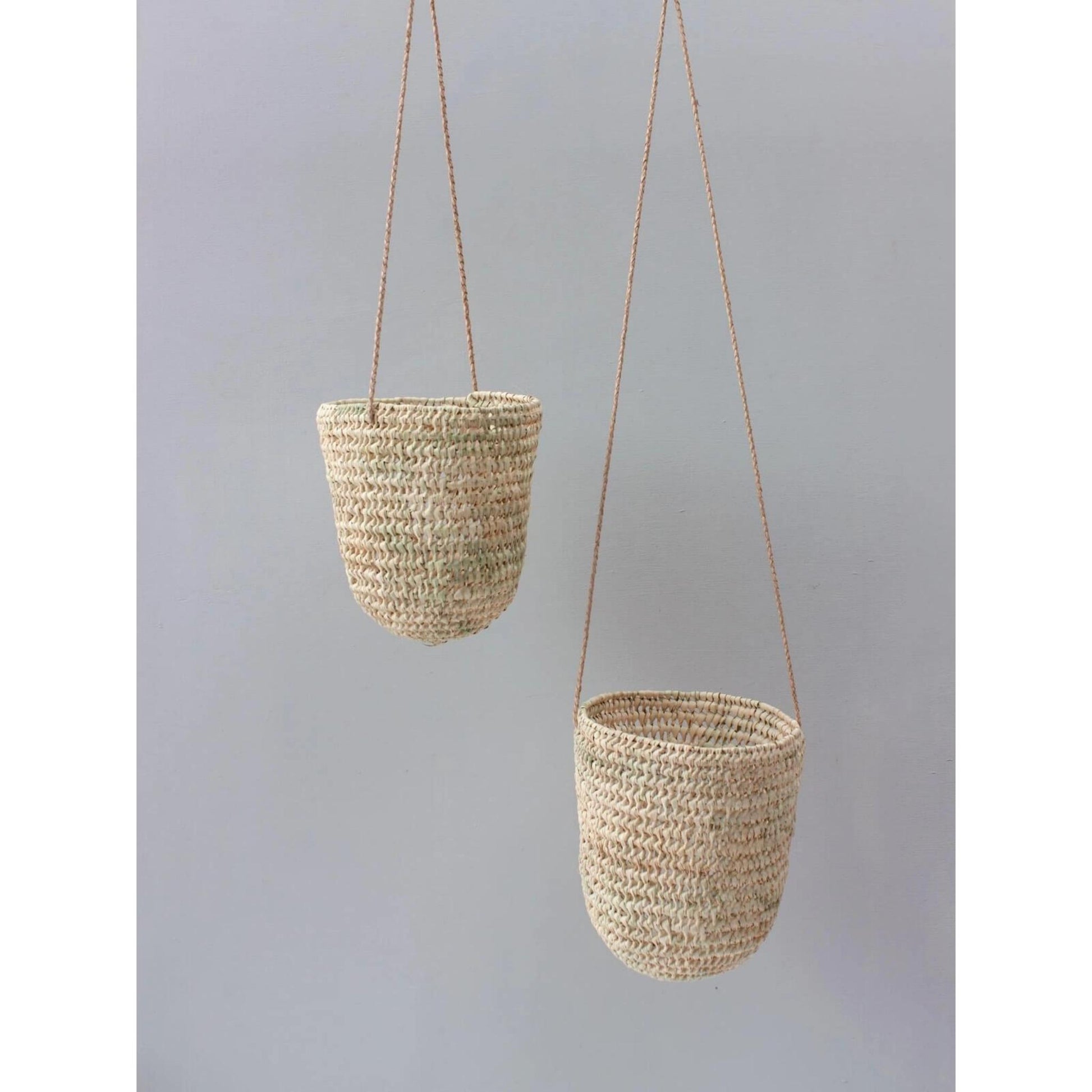 handwoven dome-shaped hanging palm leaf basket with braided leather strap shown in small and large
