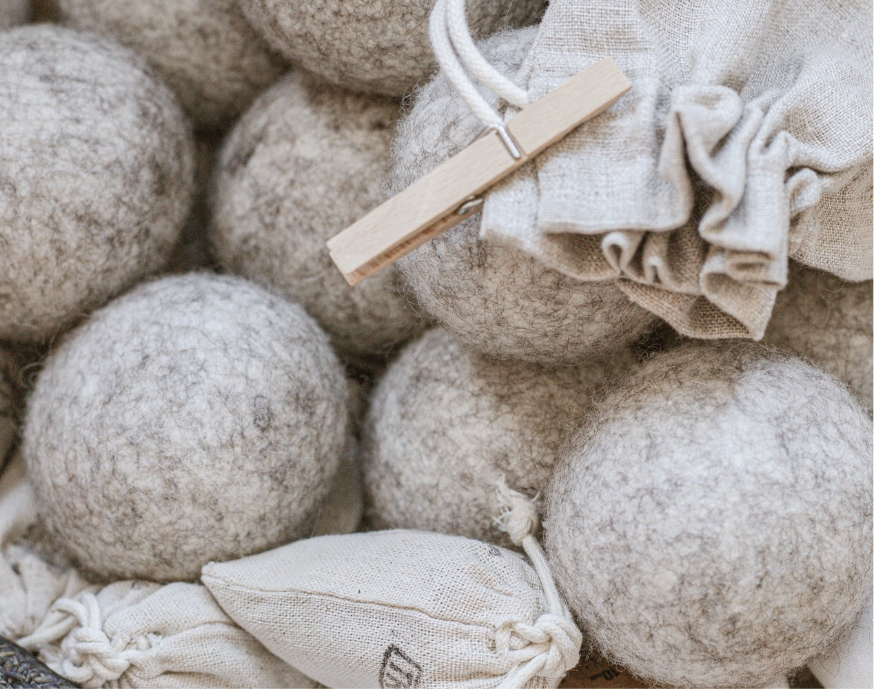 Wool dryer balls, linen bag of wooden clothes pins, and sachets of organic dried lavender