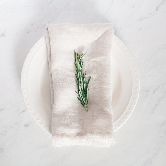 20-inch square stonewashed linen napkin with fringe edge shown in ivory