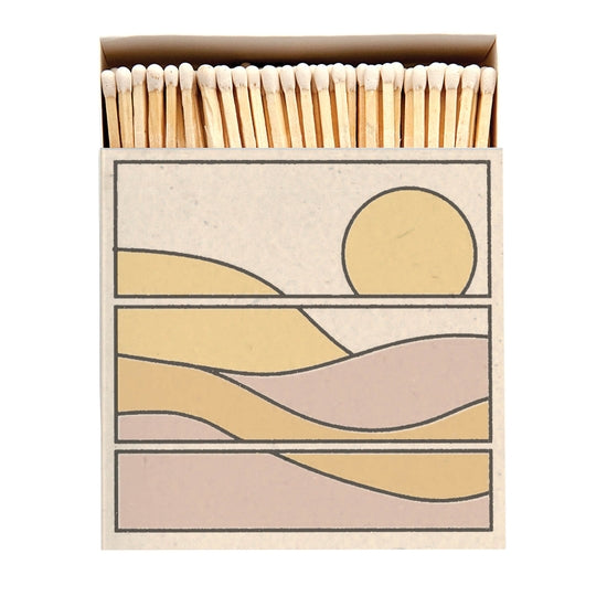 Square box of long wooden matches with graphic of sun and landscape scene 