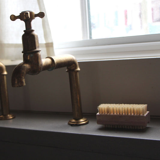 Finger Nail Brush made from tampico bristles sitting on a sink