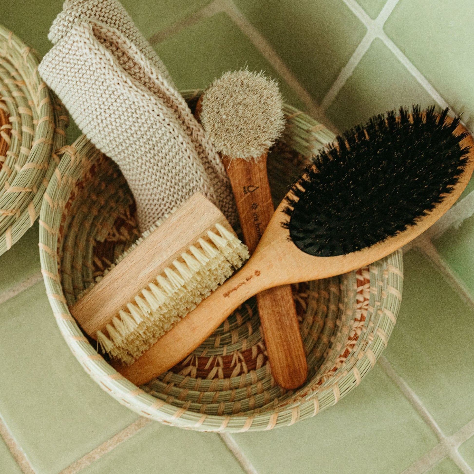 Finger Nail Brush, face-cleaning towel, hairbrush and a face exfoliating brush in a little basket