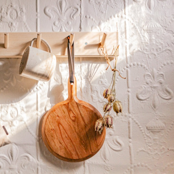 Example of the rail hanging rack with 4 peg hooks with a pan, a mug and flowers hanging on it
