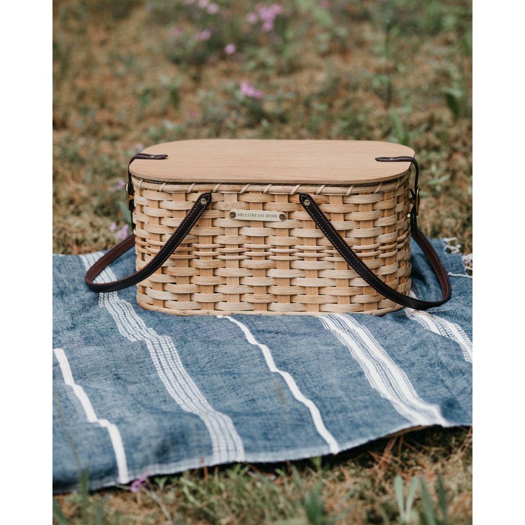 Handwoven Amish 17-inch picnic basket made of seagrass roping, wood, willow, and reed with genuine leather handles and brass saddle buckles