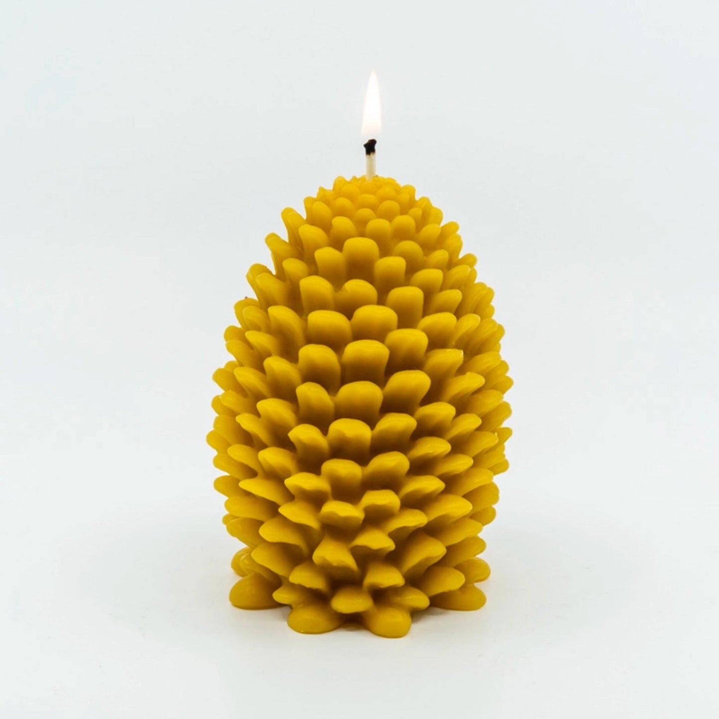 5 inch tall, hand-poured natural beeswax candle in the shape of a pinecone.