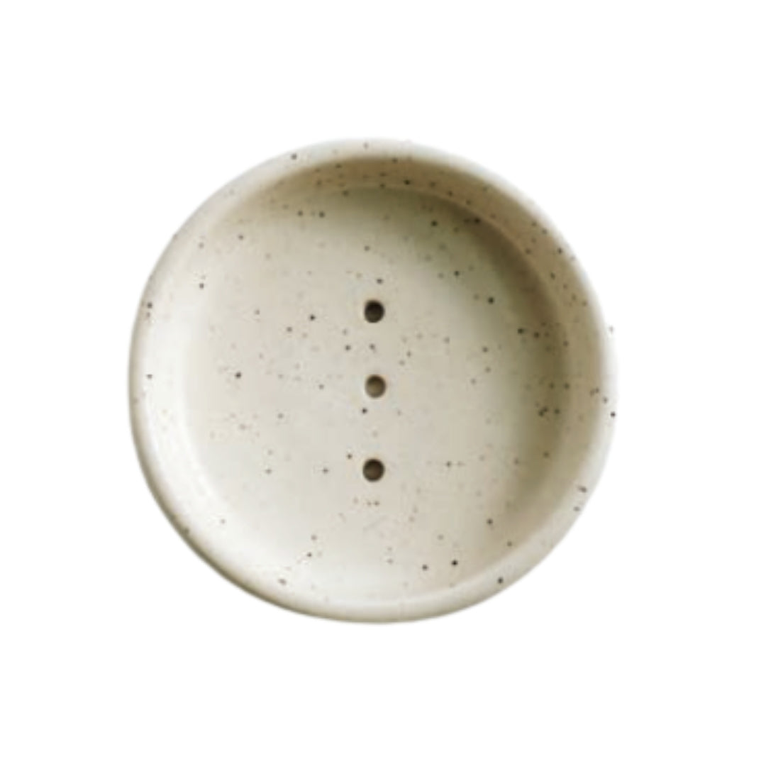 4.5 inch wide stoneware soap dish with three drain holes in white speckled glaze