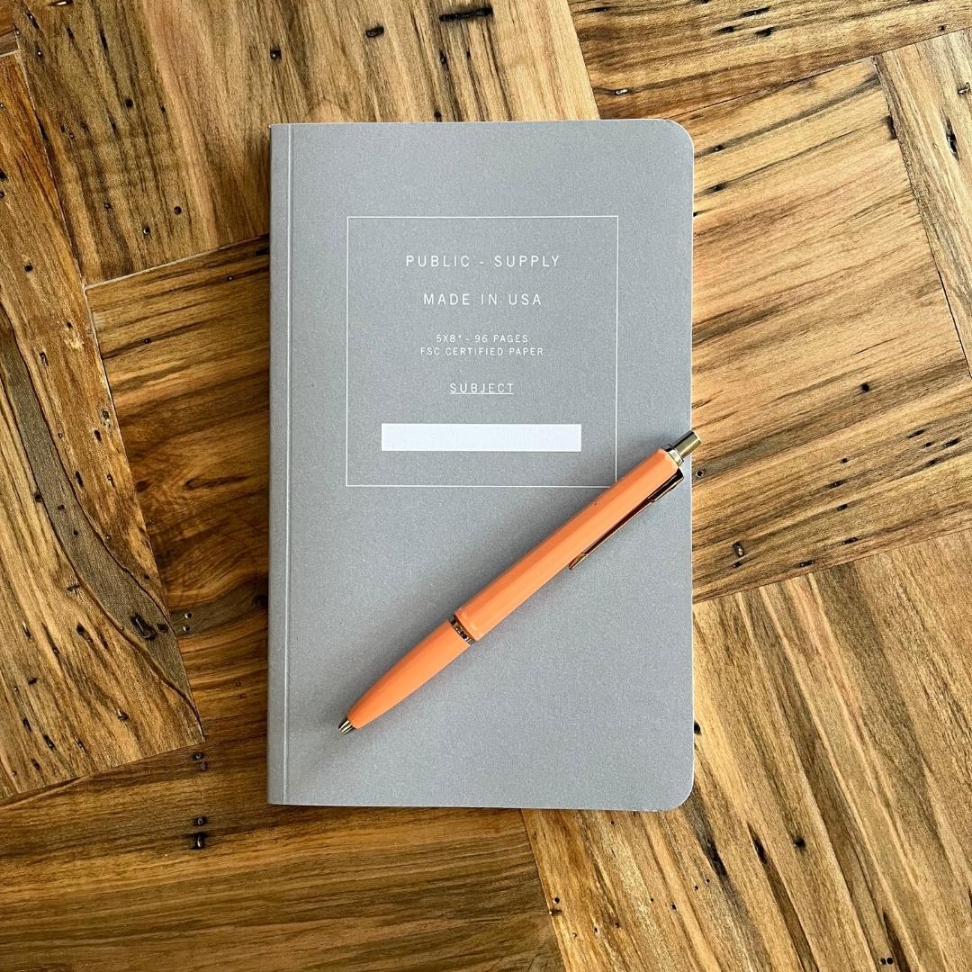 Ballograf refillable archival pen in salmon color, shown atop a notebook