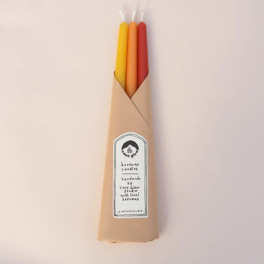10-inch tall smooth taper candles made with locally-sourced beeswax, cotton wicks, and natural dye shown in sunrise colors