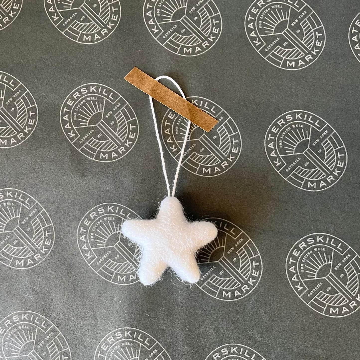 Handmade felted wool star ornament for decorating a holiday tree or adorning a gift